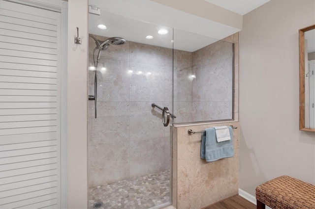 bathroom with hardwood / wood-style flooring and tiled shower