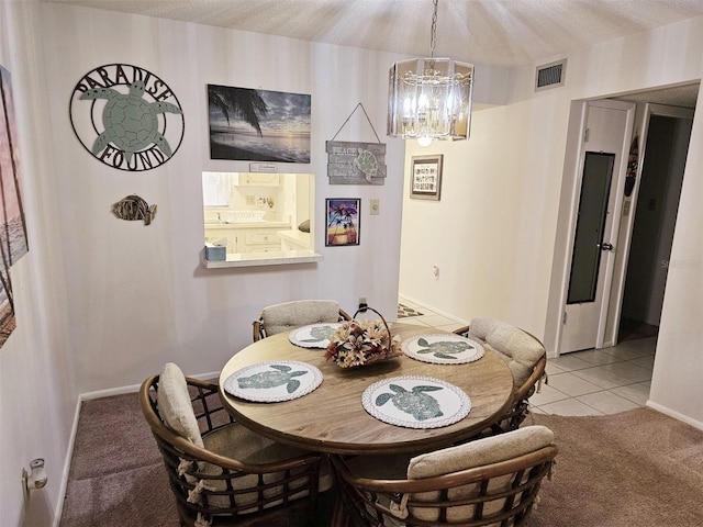 carpeted dining room featuring an inviting chandelier