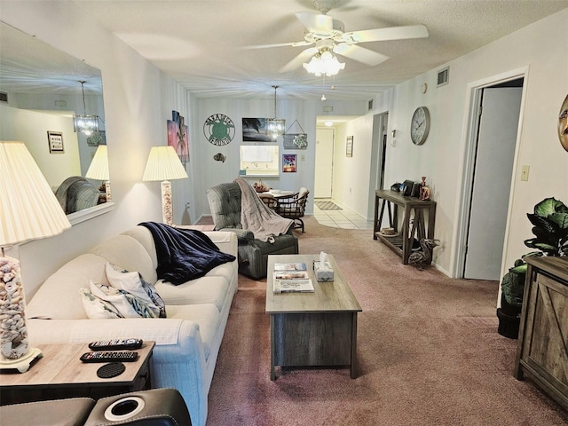 living room with ceiling fan, carpet flooring, and a textured ceiling