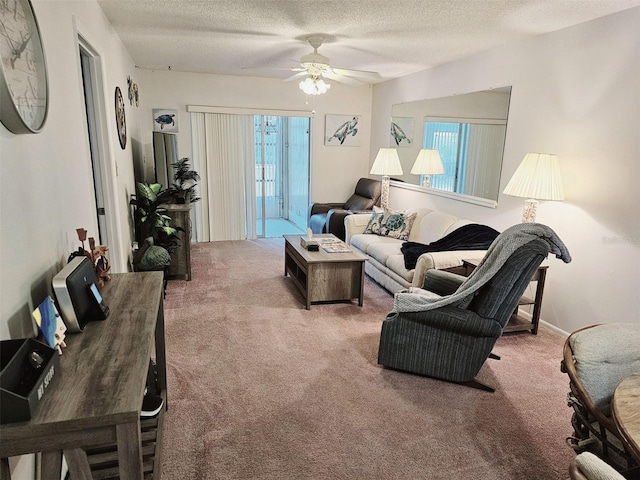 carpeted living room featuring ceiling fan and a textured ceiling