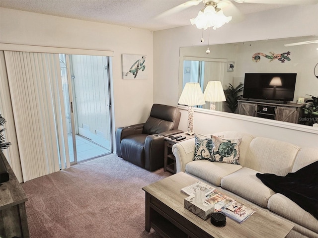 living room featuring ceiling fan, carpet, and a textured ceiling