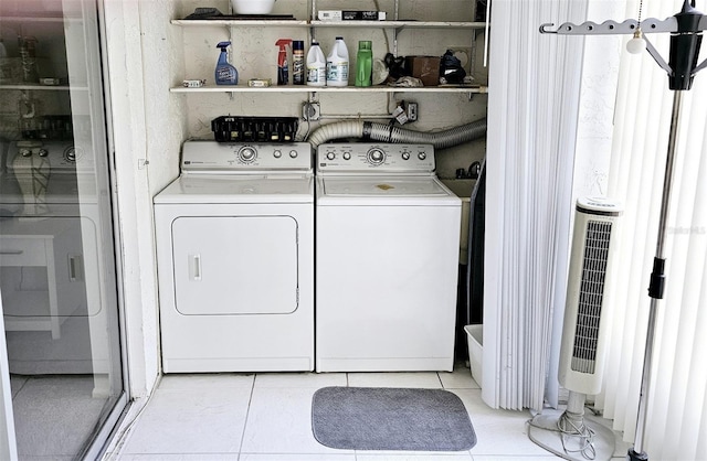 clothes washing area with separate washer and dryer, heating unit, and light tile patterned floors