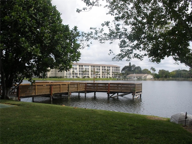 dock area featuring a lawn and a water view