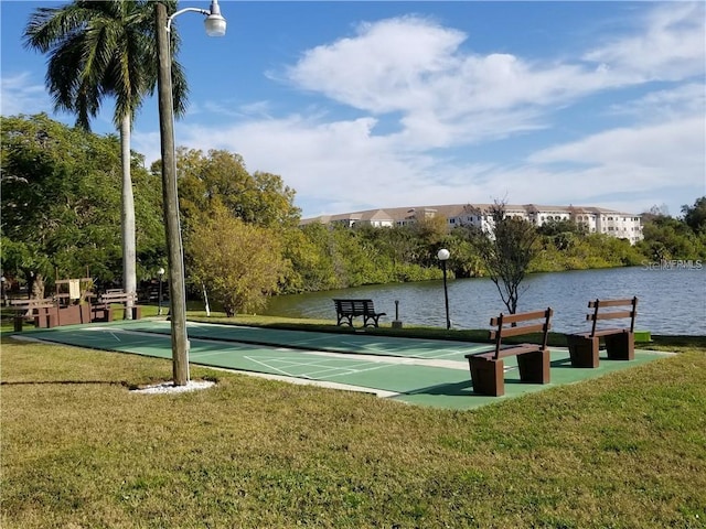 surrounding community with a water view and a yard