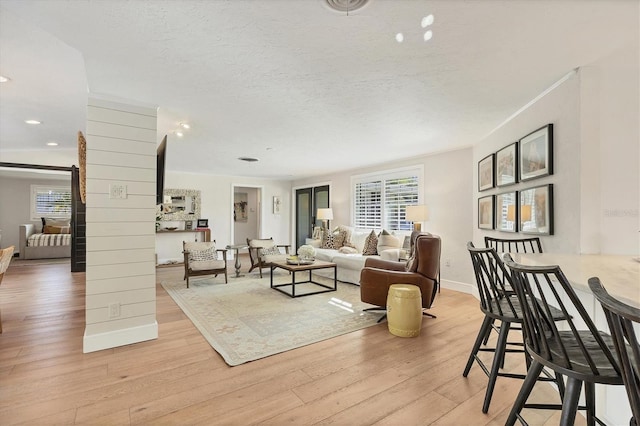 living room featuring light hardwood / wood-style floors and a textured ceiling