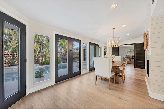 dining space featuring plenty of natural light, a barn door, and light hardwood / wood-style flooring