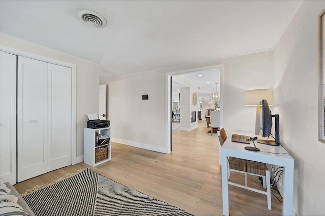 interior space with crown molding, a chandelier, and light wood-type flooring