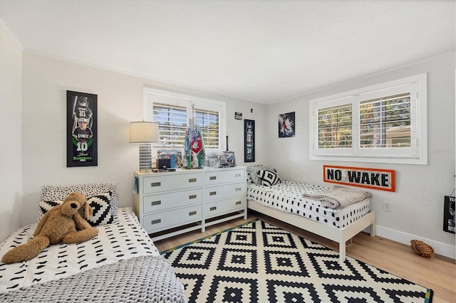 bedroom with crown molding and light hardwood / wood-style flooring