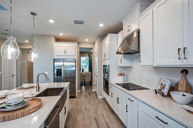 kitchen with sink, white cabinets, pendant lighting, stainless steel appliances, and backsplash