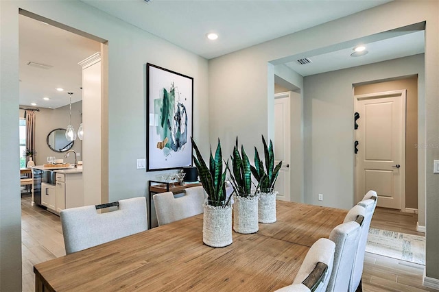 dining space with sink and light hardwood / wood-style floors