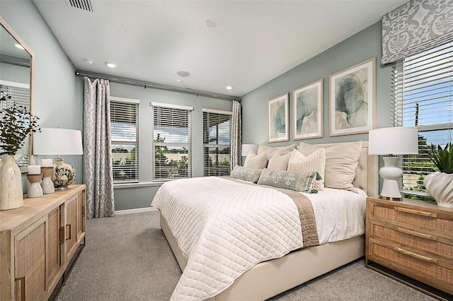 bedroom with light carpet and multiple windows