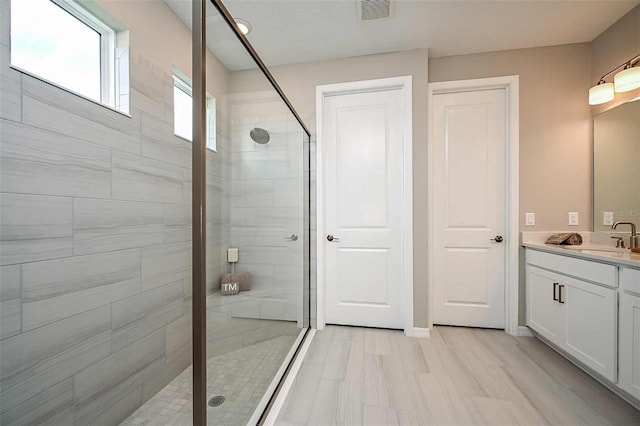 bathroom with vanity and a shower with door