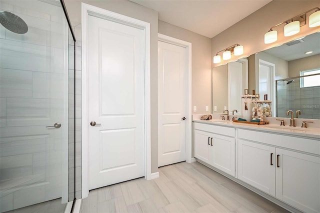 bathroom with vanity and a shower with door