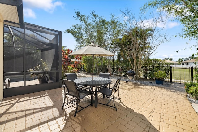 view of patio with glass enclosure and fence