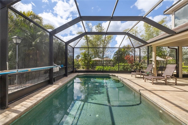 pool featuring glass enclosure and a patio