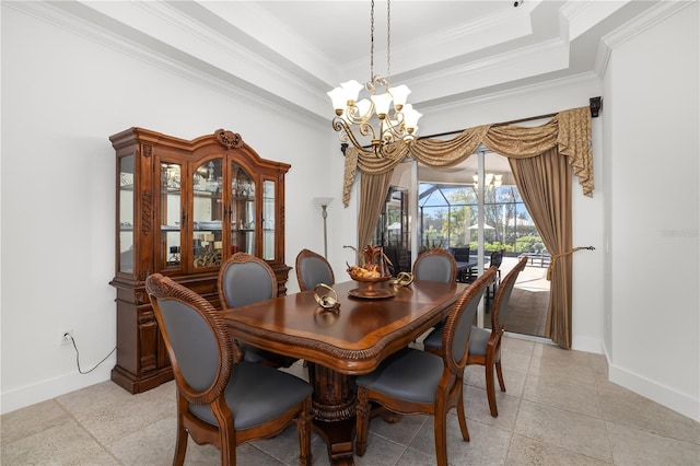 dining room with a chandelier, a raised ceiling, and baseboards