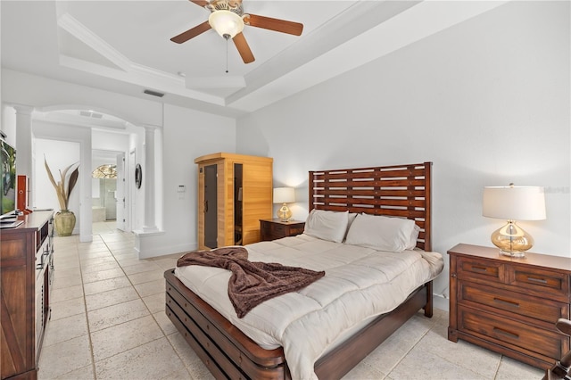 bedroom with a tray ceiling, arched walkways, visible vents, ornamental molding, and ornate columns