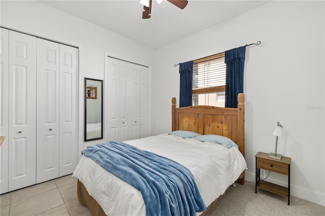 tiled bedroom featuring baseboards, ceiling fan, and multiple closets