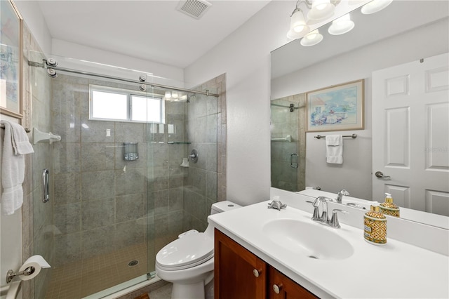 bathroom featuring toilet, a stall shower, visible vents, and vanity