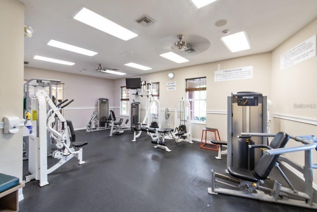 gym with a ceiling fan, visible vents, and baseboards