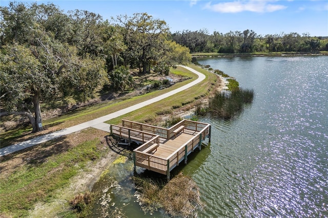 view of dock with a water view and a forest view