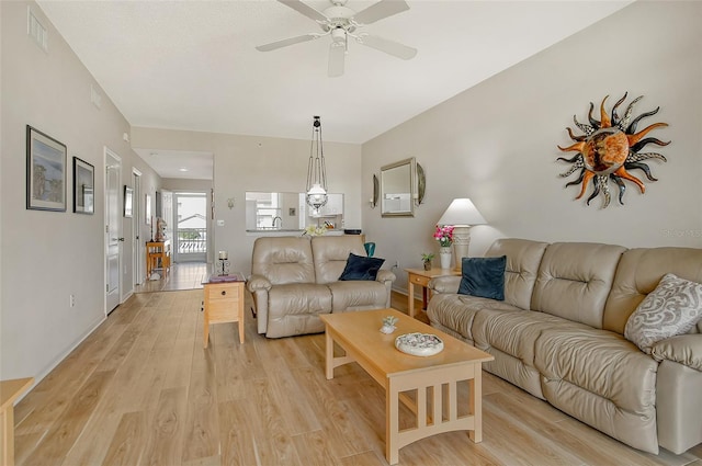 living room with ceiling fan and light hardwood / wood-style flooring