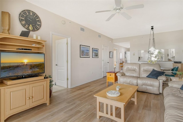 living room with light hardwood / wood-style flooring and ceiling fan