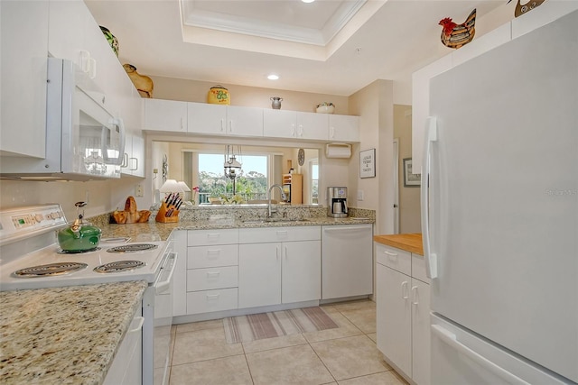 kitchen with a raised ceiling, sink, white cabinets, and white appliances