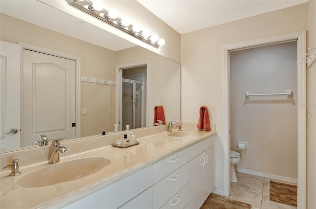 bathroom featuring walk in shower, tile patterned floors, toilet, a textured ceiling, and vanity