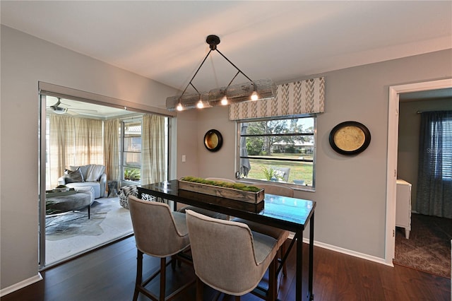 dining space with vaulted ceiling and dark hardwood / wood-style floors