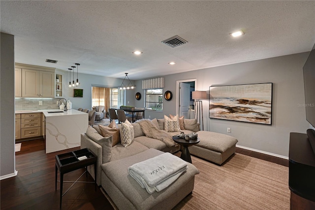 living room with sink, hardwood / wood-style floors, and a textured ceiling