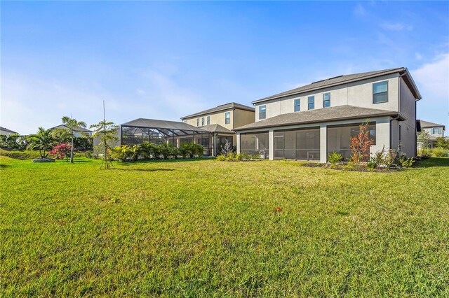 8609 Evening Dr, Sarasota, FL 34241 - back of house featuring stucco siding, a sunroom, and a yard