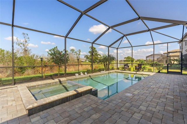 view of swimming pool with a patio area, an in ground hot tub, and glass enclosure