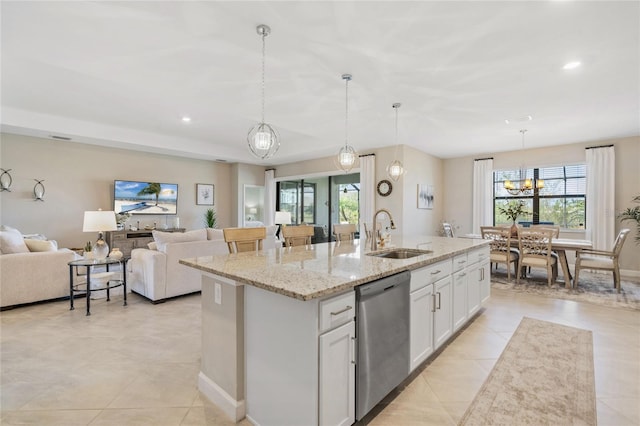 kitchen with decorative light fixtures, white cabinetry, dishwasher, sink, and a center island with sink