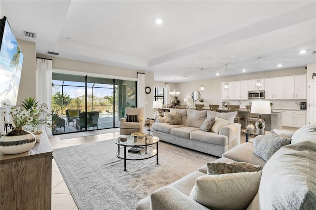 tiled living room with an inviting chandelier