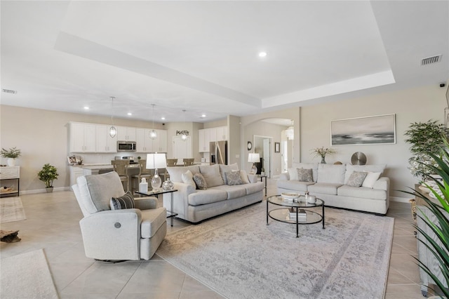 tiled living room with a tray ceiling