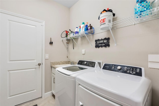 laundry area with cabinets, separate washer and dryer, and sink