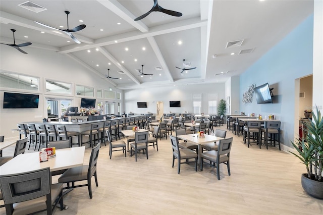 dining room featuring beamed ceiling, ceiling fan, light hardwood / wood-style floors, and high vaulted ceiling