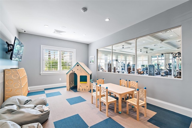 recreation room featuring coffered ceiling and beam ceiling