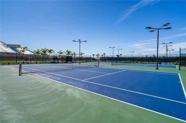 view of tennis court featuring basketball hoop