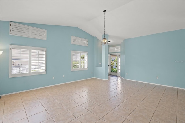 spare room with lofted ceiling, light tile patterned floors, and a chandelier