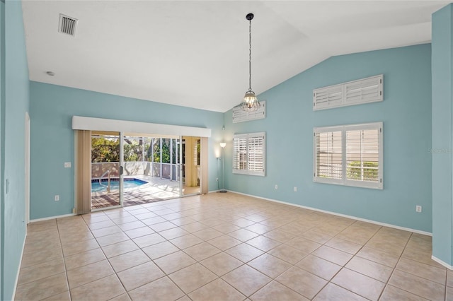 tiled spare room with high vaulted ceiling and a chandelier