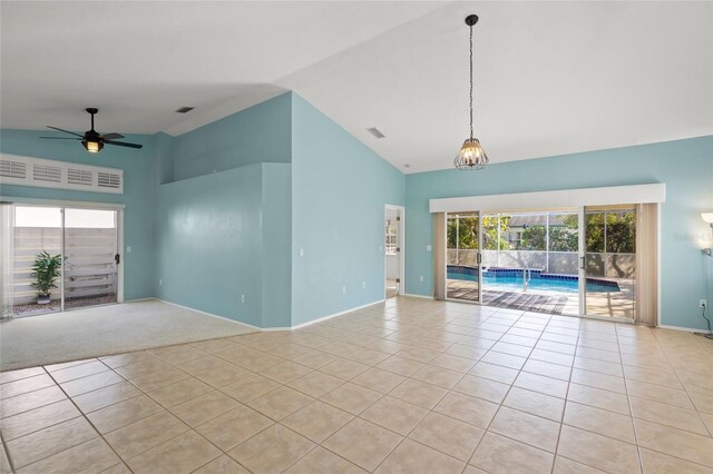 unfurnished room with light tile patterned floors, ceiling fan with notable chandelier, and high vaulted ceiling