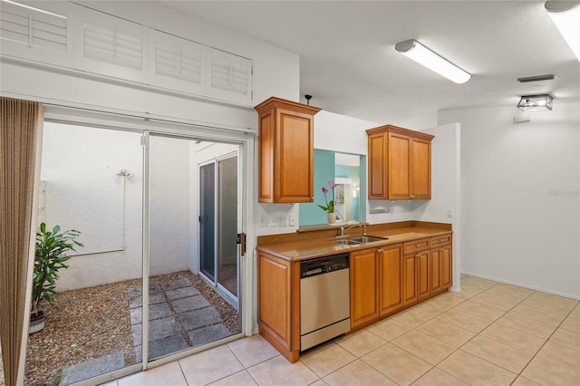 kitchen with stainless steel dishwasher, a sink, light tile patterned flooring, visible vents, and brown cabinets