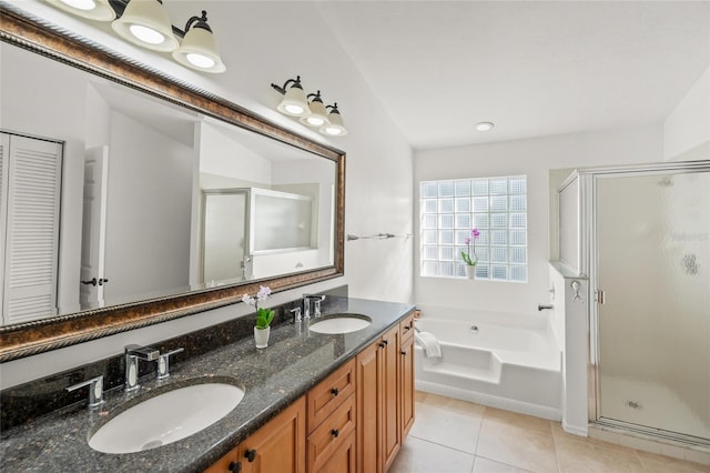 full bathroom featuring a shower stall, tile patterned flooring, a sink, and a garden tub