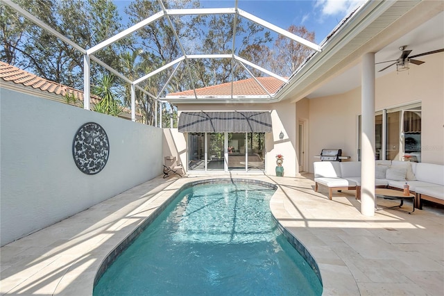 view of swimming pool with a patio, an outdoor hangout area, ceiling fan, and glass enclosure