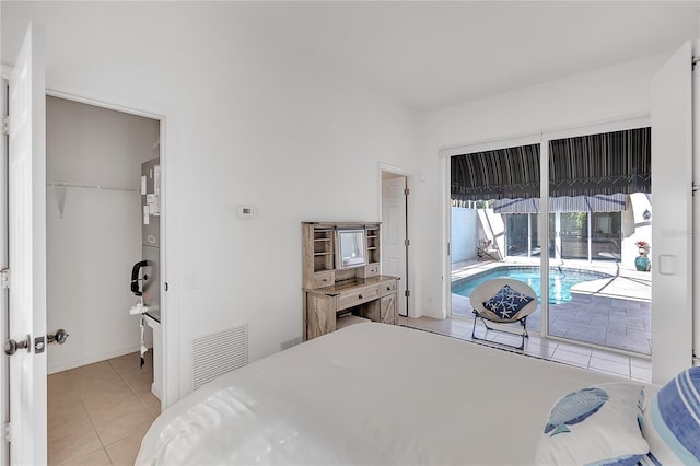 tiled bedroom featuring a spacious closet, access to outside, and a closet