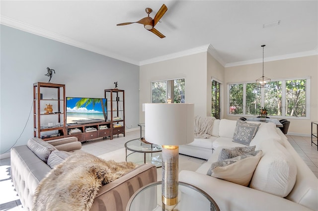 tiled living room with ceiling fan with notable chandelier and ornamental molding