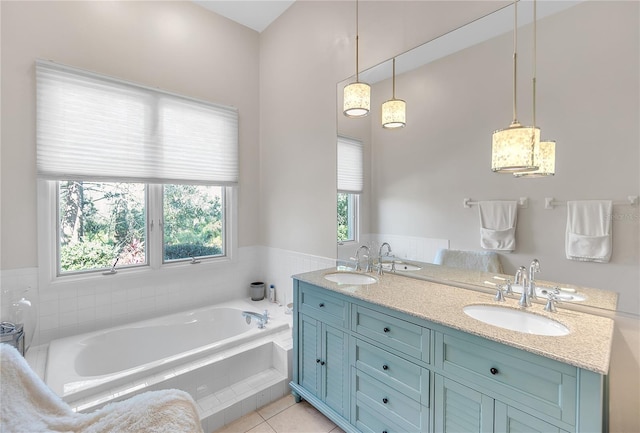 bathroom featuring a relaxing tiled tub, vanity, and tile patterned floors