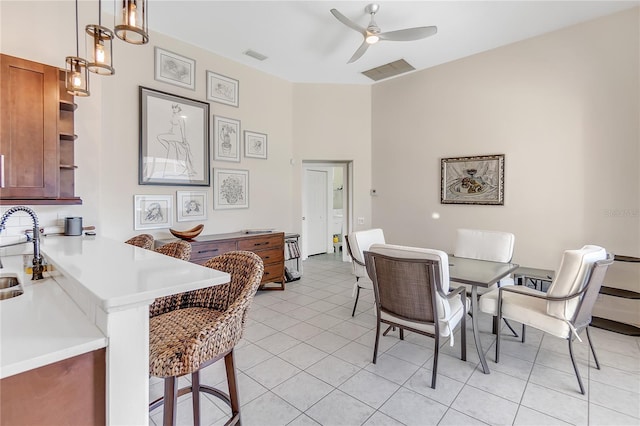 dining space with light tile patterned flooring, ceiling fan, and sink